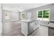 Open concept kitchen with island, stainless steel appliances, and gray vinyl plank flooring at 157 Rainbow Dr, Dunn, NC 28334