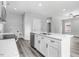 White kitchen with island, stainless steel appliances, and gray vinyl plank flooring at 157 Rainbow Dr, Dunn, NC 28334