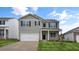 Two-story house with gray siding, white garage door, and landscaping at 1744 Post Oak Dr, Haw River, NC 27258