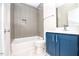Modern bathroom with blue vanity, white tub, and gray tile at 2407 Hart Street # B, Durham, NC 27703