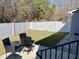 Small grassy backyard with patio, chairs, and white fence at 26 Wildberry Ct, Rocky Mount, NC 27804