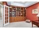 Home office with large wooden built-in shelves and red floral wallpaper at 310 Bordeaux Ln, Cary, NC 27511