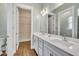 Double vanity bathroom with light gray cabinets, a large mirror, and a walk-in closet at 313 Warm Wind Dr, Clayton, NC 27527