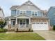 Two-story home with stone accents and a covered porch at 325 Quarryrock Rd, Holly Springs, NC 27540