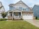 Two-story home with stone accents and a covered porch at 325 Quarryrock Rd, Holly Springs, NC 27540