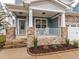 Charming front porch with rocking chairs and stone pillars at 325 Quarryrock Rd, Holly Springs, NC 27540