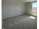 A bedroom with neutral walls, neutral carpet, a small closet, and a window overlooking the yard at 467 Ravensworth Dr, Garner, NC 27529
