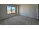 A bedroom with neutral walls, neutral carpet, and a window overlooking the yard at 467 Ravensworth Dr, Garner, NC 27529