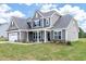 Traditional home exterior featuring a manicured lawn, stone accents, and gray siding at 467 Ravensworth Dr, Garner, NC 27529