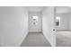 Narrow hallway with neutral colored walls and a view into the adjacent room at 467 Ravensworth Dr, Garner, NC 27529