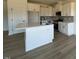 Bright kitchen showcases white cabinetry, stainless appliances, island with sink, and hardwood floors at 467 Ravensworth Dr, Garner, NC 27529