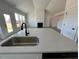 Modern kitchen featuring a center island with a sink, sleek countertops, and stainless steel appliances at 467 Ravensworth Dr, Garner, NC 27529