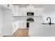Well-lit kitchen featuring white cabinets, stainless steel appliances, and a quartz countertop island at 467 Ravensworth Dr, Garner, NC 27529