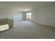 A living room featuring neutral walls, neutral carpet, a window overlooking the yard, and a storage closet at 467 Ravensworth Dr, Garner, NC 27529