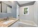 Clean bathroom with granite countertop, white sink, and a bathtub at 520 Avon Ave, Burlington, NC 27215