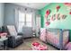 A charming Bedroom with a crib, rocking chair, and pastel pink decor at 58 Northview Dr, Middlesex, NC 27557