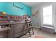 A cozy bedroom with a bunk bed, a large window with light curtains, and a blue accent wall at 58 Northview Dr, Middlesex, NC 27557