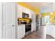 Bright kitchen features stainless steel appliances, white cabinetry and yellow accent wall at 58 Northview Dr, Middlesex, NC 27557