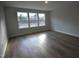 Well-lit bedroom with hardwood floors and three large windows at 60 Accord Dr, Youngsville, NC 27596