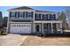Charming two-story home featuring a two-car garage, covered front porch, and well-manicured lawn at 60 Accord Dr, Youngsville, NC 27596
