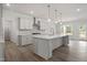 Open kitchen with white cabinets, large island, and stainless steel range hood at 60 Accord Dr, Youngsville, NC 27596