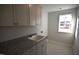 Laundry room with granite countertops, tile flooring, upper cabinets and natural light at 60 Accord Dr, Youngsville, NC 27596