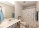 Clean bathroom with a white vanity, gray cabinets, and a shower with a fun, patterned curtain at 68 Streamline Ct, Lillington, NC 27546