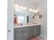 Modern bathroom featuring double vanity with gray cabinets, white countertop, and large mirror with decorative lights at 68 Streamline Ct, Lillington, NC 27546