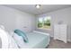 Bright bedroom with a light blue bedspread, natural light, and double door closet at 68 Streamline Ct, Lillington, NC 27546