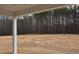 Backyard with covered patio featuring a sprawling view of towering pine trees and open space at 70 Accord Dr, Youngsville, NC 27596