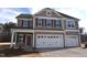 Two-story home with neutral siding, black shutters, and a three-car garage on a sunny day at 70 Accord Dr, Youngsville, NC 27596
