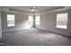 Large main bedroom with tray ceilings, three large windows, neutral paint, and carpet flooring at 70 Accord Dr, Youngsville, NC 27596