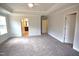 Spacious main bedroom with plush carpeting, a ceiling fan, and a doorway leading to the ensuite bathroom at 70 Accord Dr, Youngsville, NC 27596