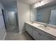 Bathroom featuring double sinks, large mirror, tile floors, and a walk-in shower at 75 Calabria Ct, Franklinton, NC 27525