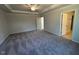 Large bedroom with a tray ceiling, carpeted floors, and ensuite bathroom access at 75 Calabria Ct, Franklinton, NC 27525