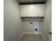 Laundry room with overhead storage cabinets and tile flooring at 75 Calabria Ct, Franklinton, NC 27525