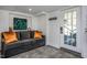 Cozy basement living area with grey sofa, orange pillows, and access to backyard at 807 E Edenton St, Raleigh, NC 27601