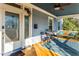 Relaxing front porch with a swing, seating area, and blue rug at 807 E Edenton St, Raleigh, NC 27601
