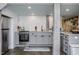 Modern gray kitchen with stainless steel appliances and white herringbone tile backsplash at 807 E Edenton St, Raleigh, NC 27601