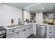 Modern gray kitchen with stainless steel appliances and white herringbone tile backsplash at 807 E Edenton St, Raleigh, NC 27601