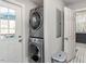 Stackable washer and dryer in a small laundry room with white door and tile floor at 807 E Edenton St, Raleigh, NC 27601