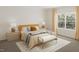 Bright bedroom with a mustard-colored bed and large window at 100 S Stonemill Trl # Homesite 234, Clayton, NC 27520
