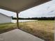Covered back porch, overlooking a large grassy backyard and a white picket fence at 107 Pretty Run Branch Ln, Wendell, NC 27591