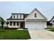 Charming two-story home with a two-car garage, green lawn, and covered front porch with wooden pillars at 107 Pretty Run Branch Ln, Wendell, NC 27591