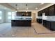 Spacious kitchen with dark cabinetry, stainless steel appliances, and a large island with pendant lighting at 107 Pretty Run Branch Ln, Wendell, NC 27591