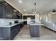 Beautiful kitchen with dark wood cabinets, granite counters, stainless appliances, and an open living area at 107 Pretty Run Branch Ln, Wendell, NC 27591
