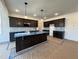 Bright and airy kitchen featuring dark cabinets, an island with sink, and modern pendant lighting at 107 Pretty Run Branch Ln, Wendell, NC 27591