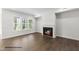 Living room features a fireplace, wood floors, and natural light from the windows at 107 Pretty Run Branch Ln, Wendell, NC 27591
