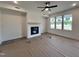Inviting living room with a modern fireplace, ceiling fan, and large windows that fill the space with light at 107 Pretty Run Branch Ln, Wendell, NC 27591