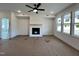 Cozy living room featuring a fireplace, a ceiling fan, and ample natural light from the large windows at 107 Pretty Run Branch Ln, Wendell, NC 27591